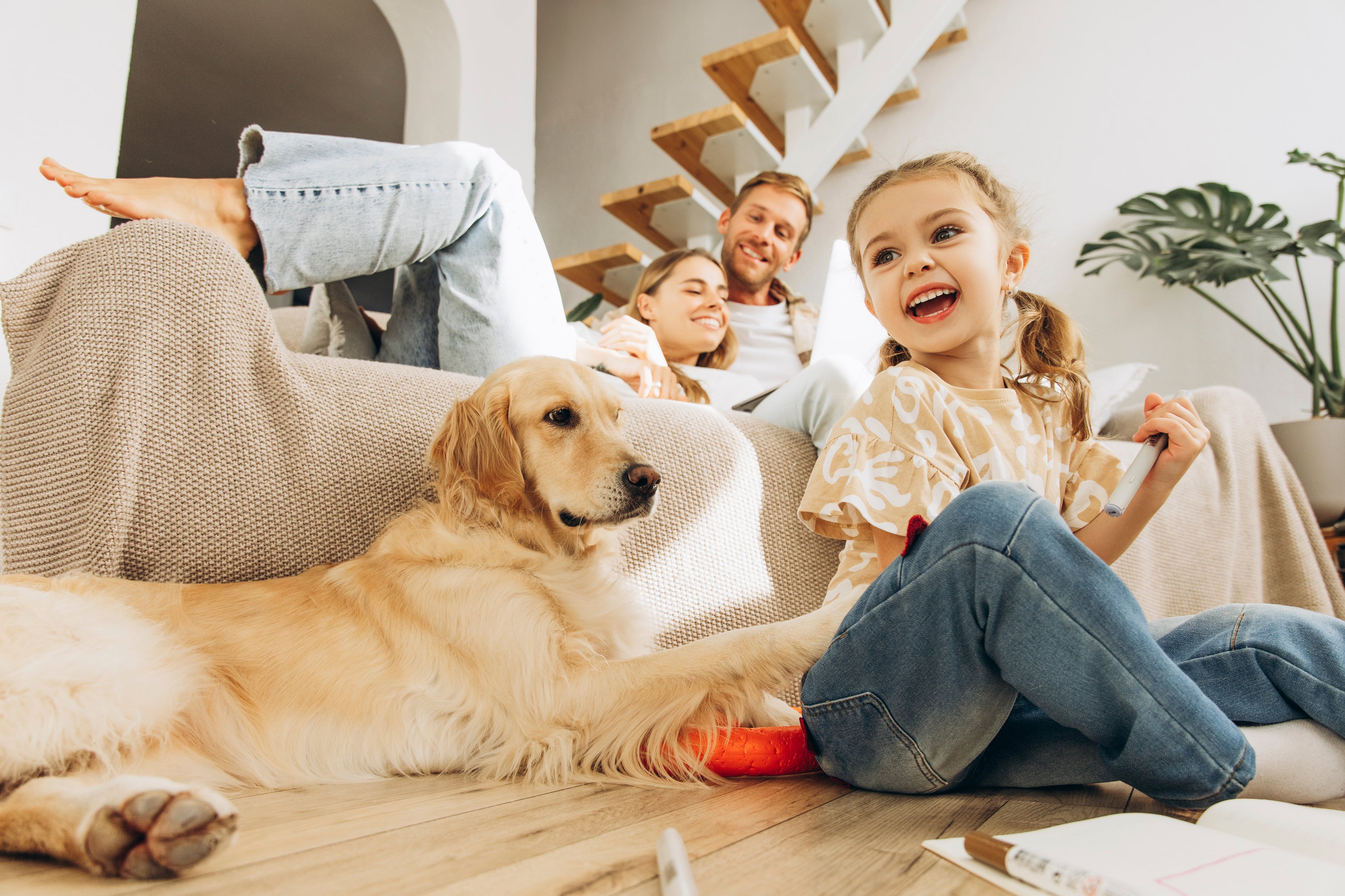Family relaxing on a clean couch with their pet